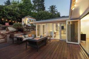 House with a huge deck and backyard furniture. Nice trees in the back of the house